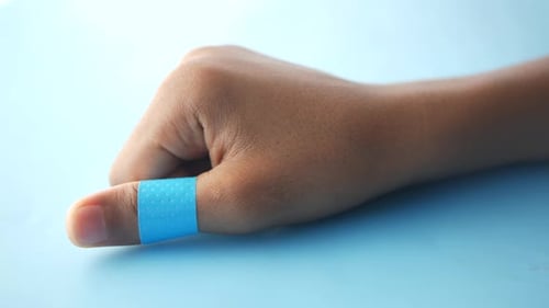Hand with Blue Bandage on Thumb, Close Up