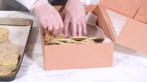 Packing SprinkleAdorned Sugar Cookies Into Boxes