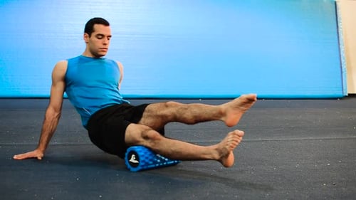 Man Uses Foam Roller for Thigh Exercise