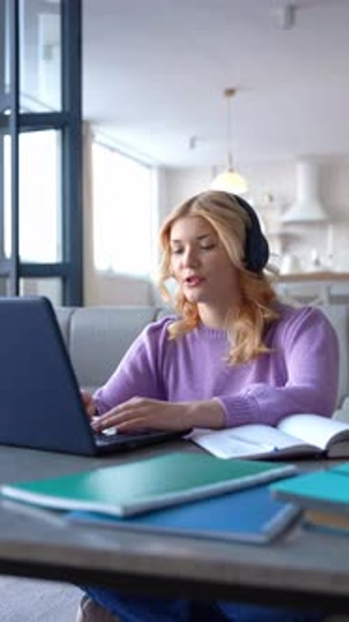 Woman Attends Online Meeting with Laptop and Headphones