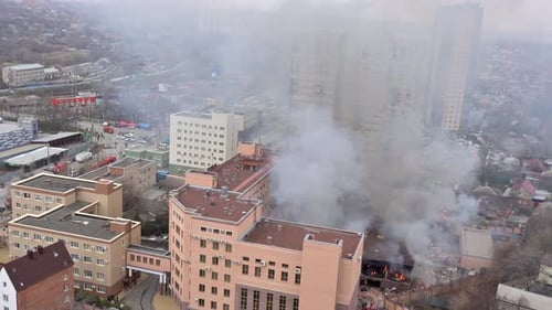 Vue aérienne des pompiers qui éteignent un incendie dans une zone industrielle ou résidentielle près d'un bureau