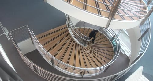 Geschäftsmann geht auf dem Weg zur Besprechung im Büro die Treppe hinauf
