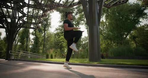 Athletic Man Performs High Knees in Park