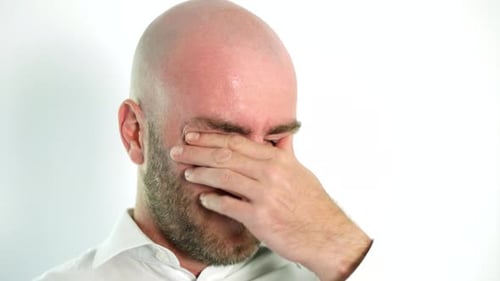 Tired man removes gasses and rubs eyes