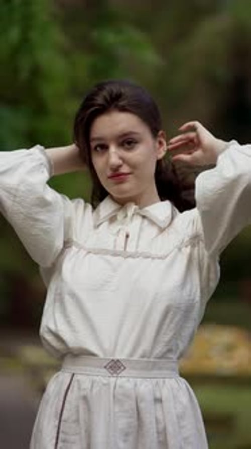 Close Up Beauty Portrait of Young Brunette Woman with Long Dark Hair Touching Her Hairstyle Standing