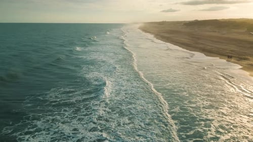 Drone aerial view of paradise beach. Turquoise sea water and clear sand at sunset.