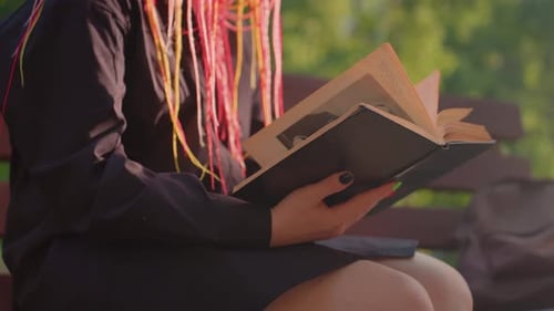 Young Person with Vibrant Braids Enjoying Peaceful Park Reading Experience Individual with