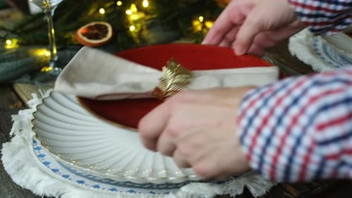 Setting a festive table with plates and napkin