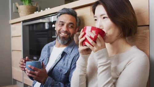 Couple Enjoying Hot Drinks Together in Modern Kitchen