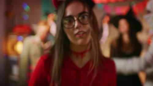 Halloween Costume Party: Zoom in Portrait of Beautiful She Devil with Trident Does Evil Smile. In t