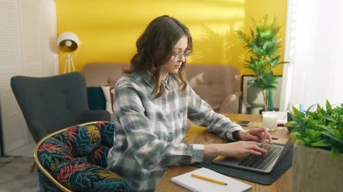 Profile Shot of Diligent Female Student Typing Fast on Laptop Sitting at Table
