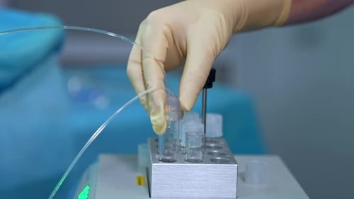 Les
mains gantées du docteur tiennent le tube à essai avec des tubes. En gros plan. Équipement pour la FIV.