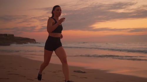Athletic Woman Jogging on Ocean Beach at Sunset Background