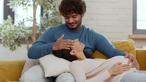 Pregnant woman relaxing with partner at home