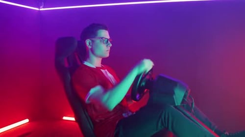 Focused Gamer Playing a Racing Simulator Machine Multicolor Neon Light Game Tournament Soft Focus
