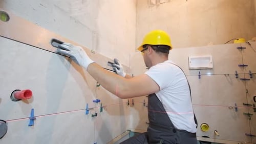 Construction Worker Using Level in Bathroom Renovation