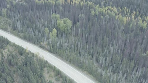 dolly roll aerial over mountain valley highway freeway road with sparce vehicle traffic surrounded b