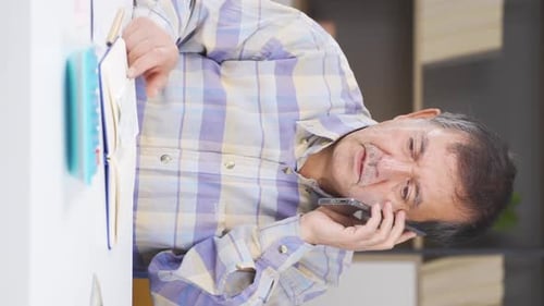 Man with Gray Hair Talking on Cellphone Indoors