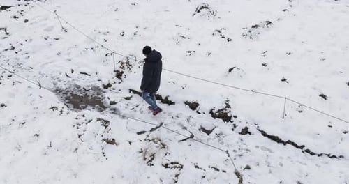 Man Walking On Snowy Icelandic Landscape