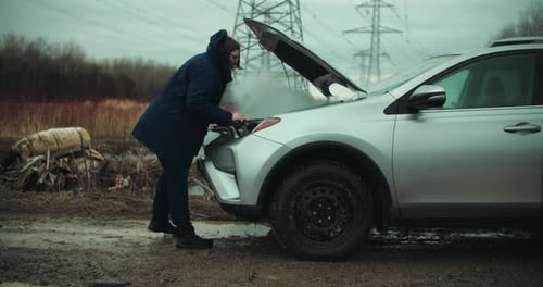 Frustrated Woman Inspecting Smoke Coming out of Broken Car Engine. Road Side Accident Vehicle Breakd