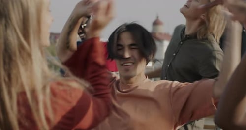 Diverse Friends Dancing at Rooftop Party, Daytime