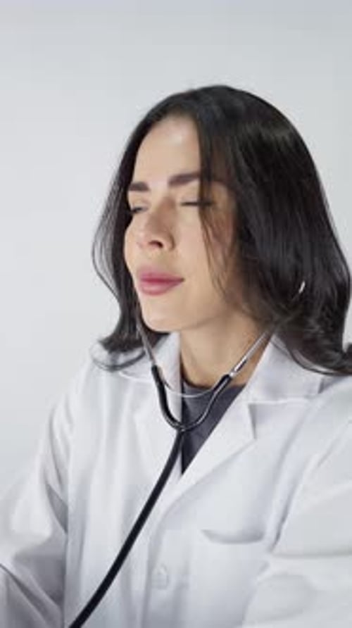 Woman Doctor Puts Stethoscope in Ears, White Background