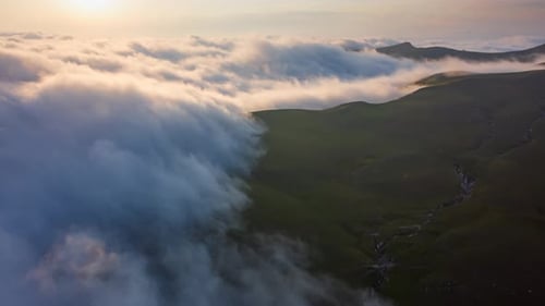 Cinematic timelapse of fluffy clouds moving softly over mountain plateau at sunset