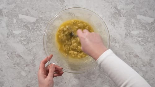 Time Lapse Smashing Riped Bananas in a Glass Mixing Bowl to Prepare Coconut Banana Pancakes