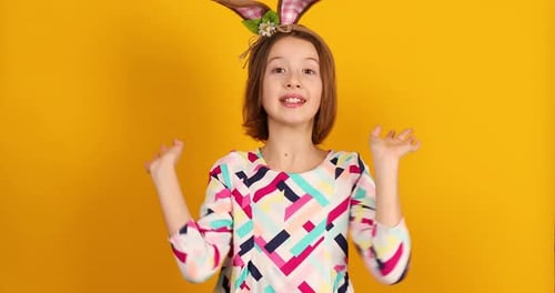 Girl with Bunny Ears Waving on Yellow Background