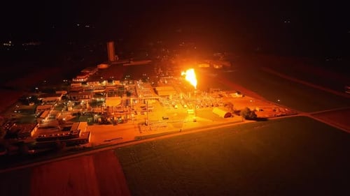 Observing Gas Flaring Casting its Light Across the Plant - Pan Up Shot
