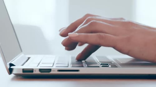 Hands Typing on Silver Laptop Keyboard Close Up