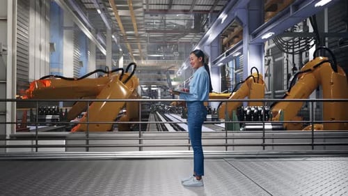Woman Works on Laptop in Automated Factory
