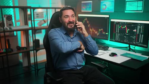 Man Talking On Phone Holding Bitcoin In Office