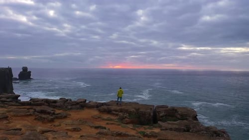 Lonely Man is Standing on the Edge of Cliff Peniche Portugal Aerial View