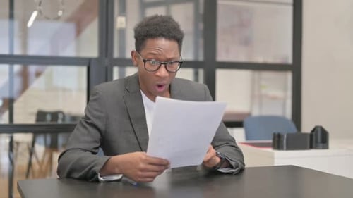 Young Man Reacts Badly to Documents at Desk