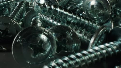 A Bunch of Metal Screws on a Black Background Metal Screws Background Made of Stainless Steel