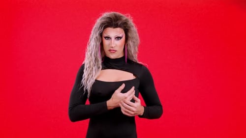 Drag Performer Poses on Red Backdrop