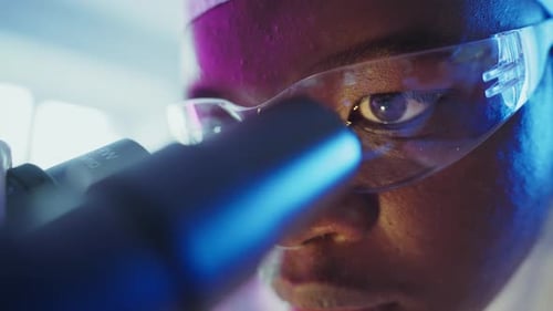 Scientist Analyzing Sample with Microscope in Laboratory