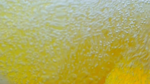 A Slice of Lemon Falls Into a Glass of Water Slow Motion Close Up
