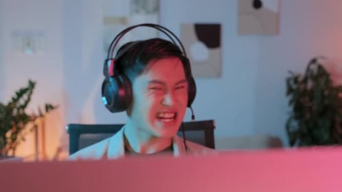 Asian Gamer Speaking in Mic while Playing Online PC Game