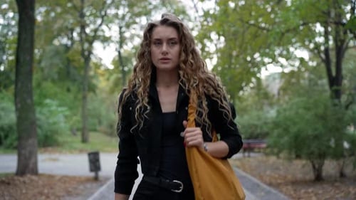 Front View Confident Gorgeous Woman Walking in City Park Leaving