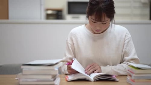 Young Adult Studying at Home with Books