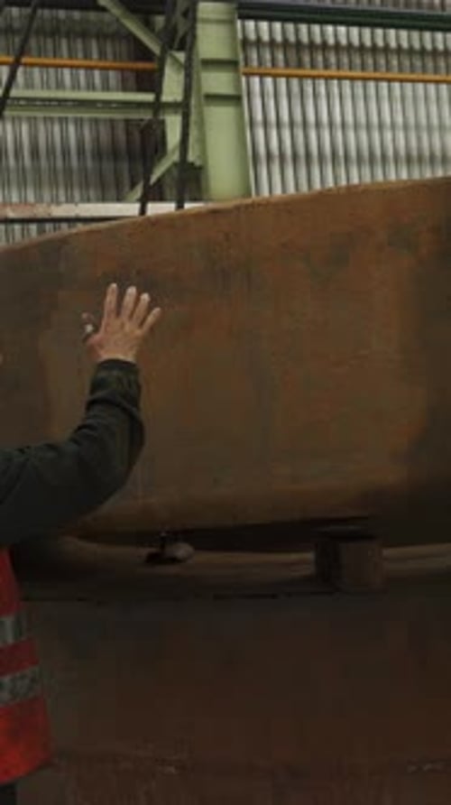 Factory Worker Guiding Placement of Large Metal Component with Hand Signals Stock Clip