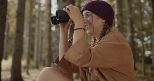 Young Woman Searching Through Binoculars in Forest