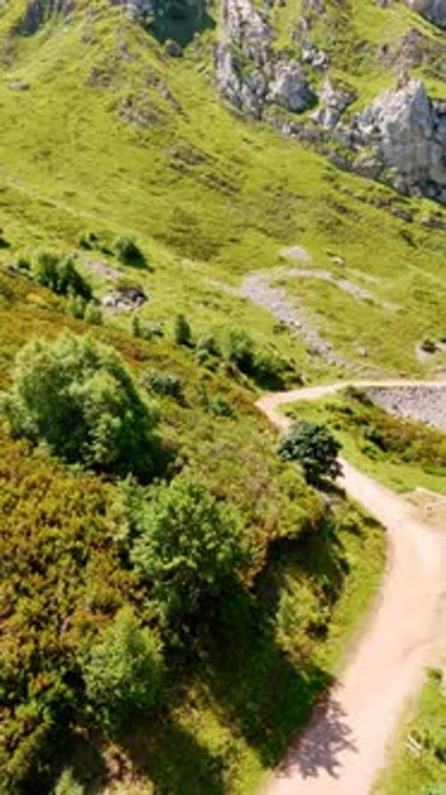 Mountainous landscape covered with beautiful greenery. Roads and trails cross the rocky scenery.