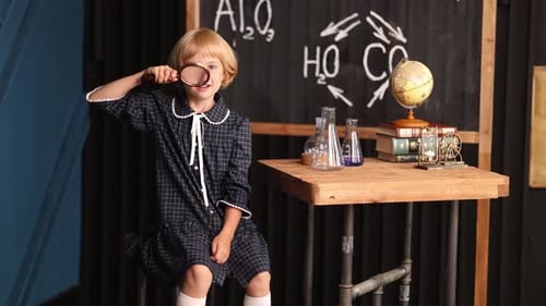 Enthusiastic Child With Magnifying Glass in Classroom