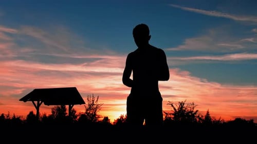 Silhouette of a Guy in Shorts and Swimming Goggles Against the Background