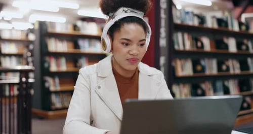 Student, headphones and woman on laptop in library typing for education, university and knowledge