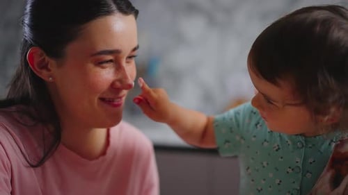 Happy Mother and Baby Touching Noses at Home