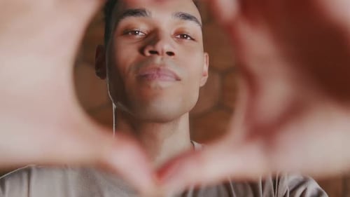 Young Man Makes Heart Shape With Hands